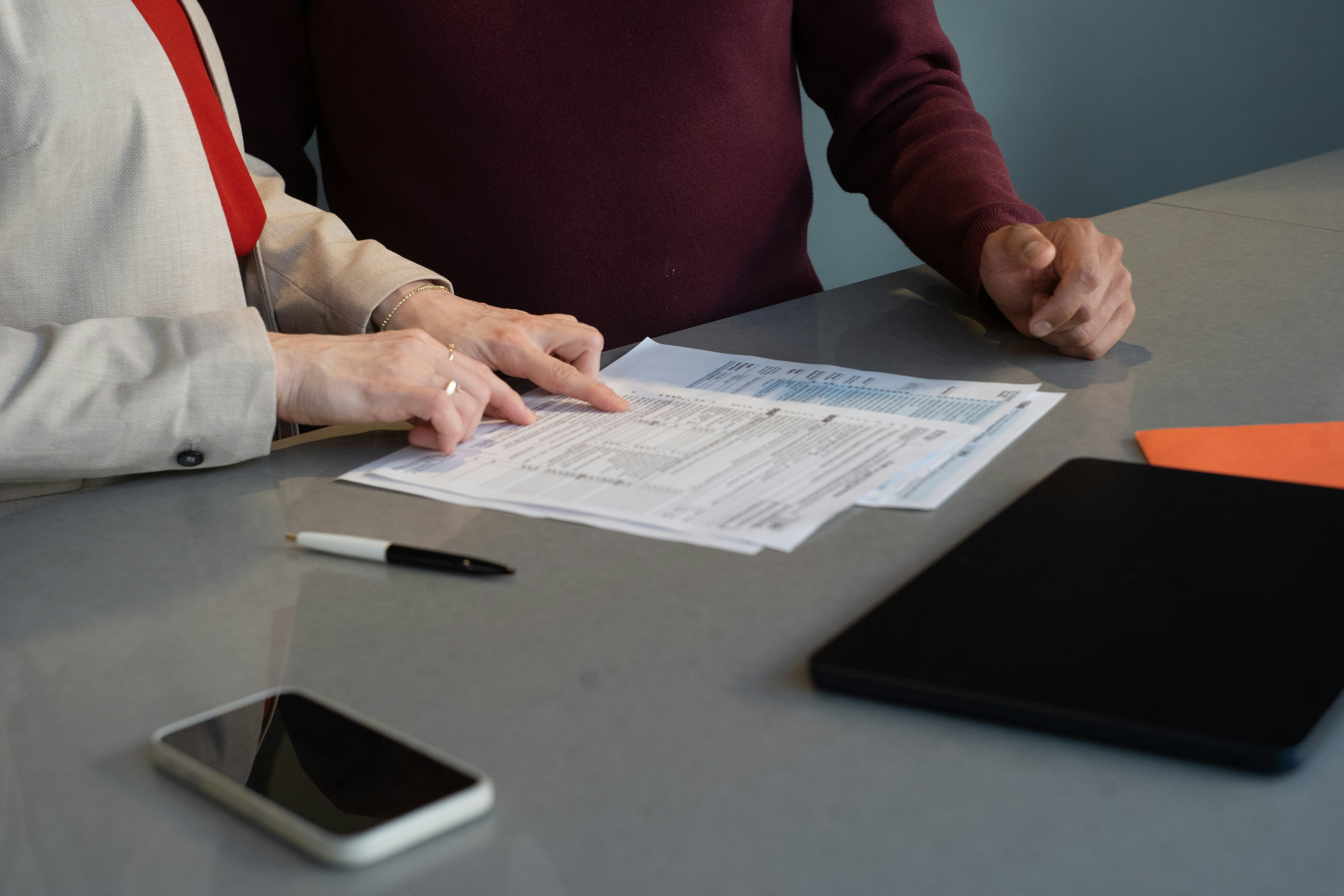 Two people review paper documents at a table in San Francisco